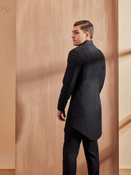 The back view of the pleated-sleeve achkan reveals the continuation of its strong, structured lines, ensuring a powerful look from every angle.