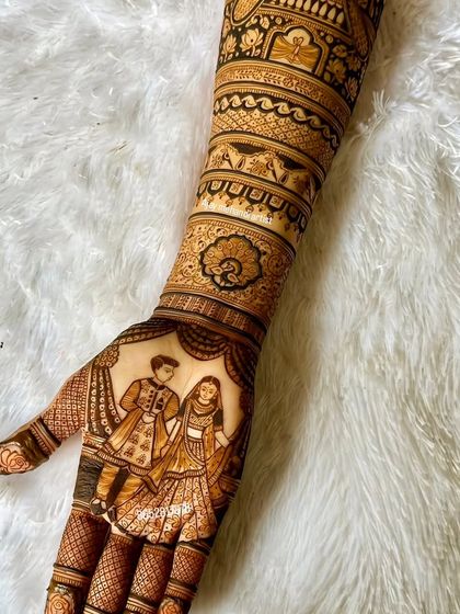 A detailed portrait of a couple on the palm, set against a white background to highlight the clean linework and shading of the henna art.