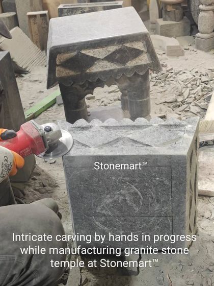 Intricate carving by hand is in progress on a granite stone temple at our workshop. This image shows the detailed work that goes into creating each sacred structure.