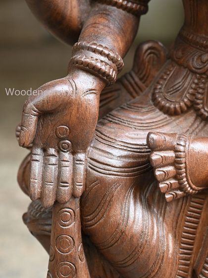 A detail of the hand of the 36-inch MahaLakshmi holding a pot of coins, symbolizing wealth.