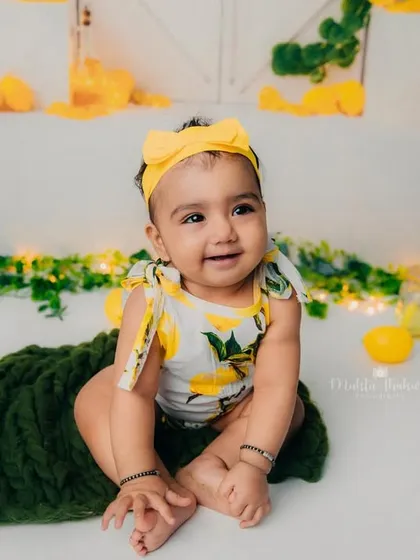 This little one is enjoying her lemonade stand. The yellow and green colors create a fresh and vibrant look.