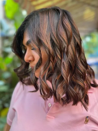 A side profile showing the beautiful layers and subtle highlights of this brunette bob. It's a classic look that's always in style.