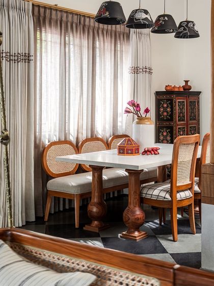 The dining space is where the family gets together. The stone-top table features massive, custom-made pillar legs that do justice to the scale of the home. Hand-painted pendants and a vintage crockery cabinet complete the traditional, hand-crafted feel.