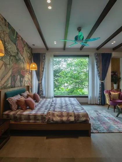 This bedroom combines bold artistic expression with natural elements. A vibrant, comic-book style mural serves as a headboard, while a large window offers a peaceful view of lush greenery, balancing energy with tranquility.