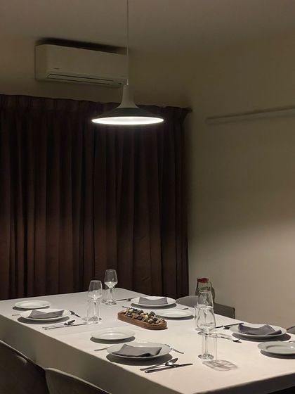 The mood is set for an evening of fine food and wine. The soft lighting and elegant table create a warm and inviting space for a private dinner.