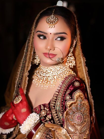 A classic bridal pose showing off the complete look. The makeup features bold eyes and a flawless base, designed to look stunning under the bright lights of a wedding celebration.