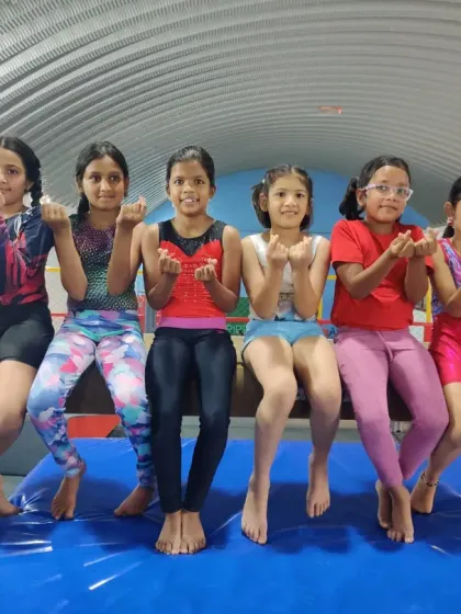 Our girls sitting on the balance beam, showing their love for the sport. The positive and fun atmosphere is a huge part of the Elite Squad experience.