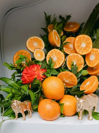 One of the styled niches, featuring a vibrant arrangement of oranges, florals, and golden safari animal miniatures.