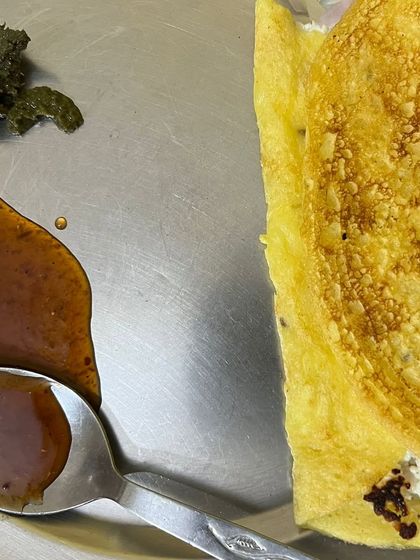 A client's meal of a besan cheela with a side of chutney and sauce. This is part of an easy-to-prepare home-based plan for a busy working professional.