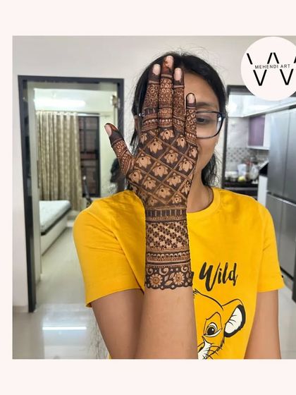 The client posing with her beautiful elephant grid henna.
