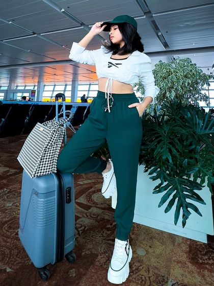 Another shot of the airport look. The baseball cap is a practical and stylish accessory for travel days.