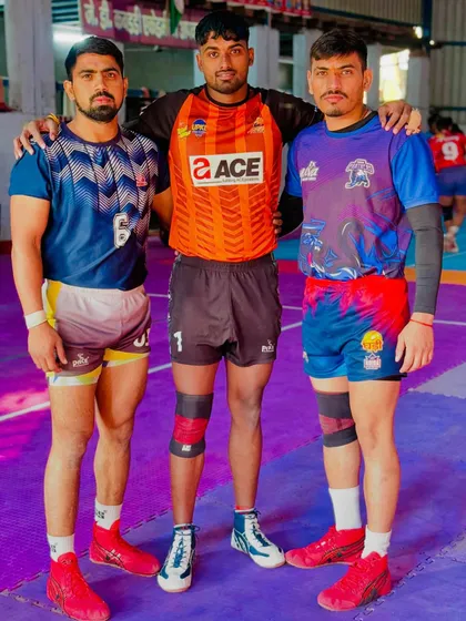 Three of my senior players, representing different teams in the Yuva Kabaddi Series, standing together at our academy.