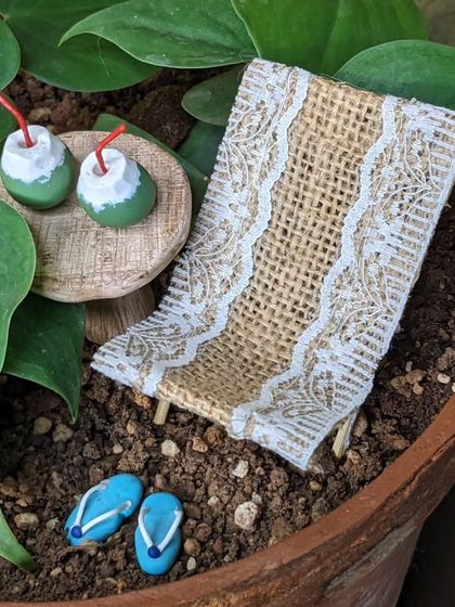 Every detail is handmade, from the tiny red straws in the coconuts to the delicate lace on the beach chair.