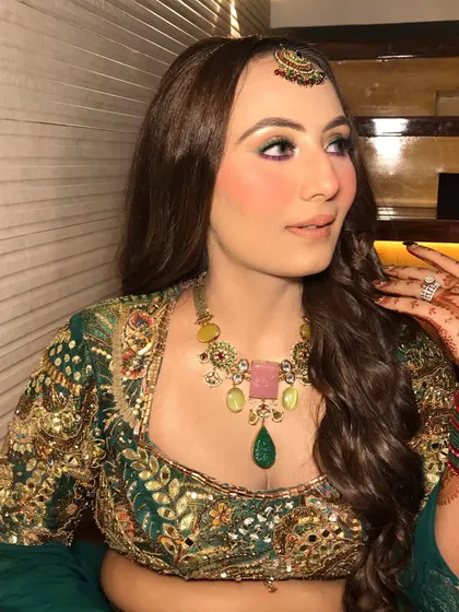 The side profile shows her crimped hair and the beautiful details of her maang tikka.