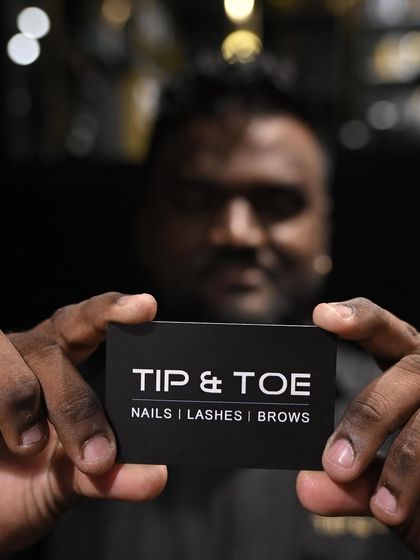 A close-up of one of our team members holding the Tip & Toe card, a symbol of our professional service.