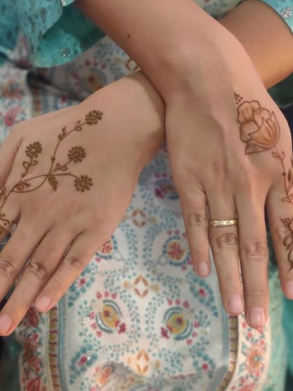 A perfect example of minimalist designs for a corporate party. Each hand has a different simple motif, like a floral vine or a single lotus, showing how quickly I can create elegant art for large groups.