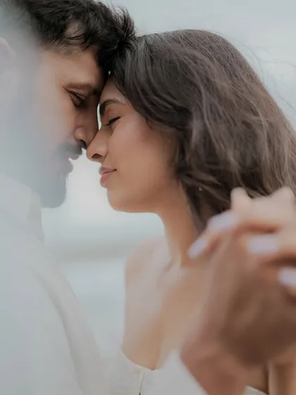 An intimate close-up where a couple holds each other, lost in the moment. This candid shot, with a soft foreground element, creates a feeling of peeking into a private, heartfelt connection.