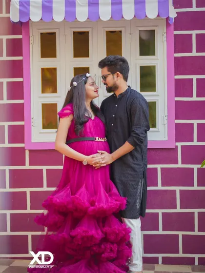 A candid moment of a couple sharing a look, captured against a playful and colorful backdrop.