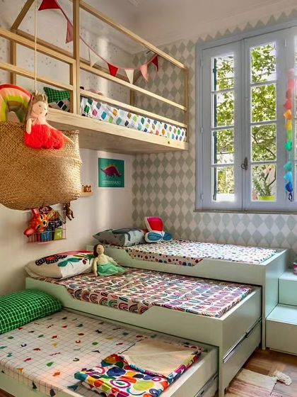 A highly creative solution for a room shared by three children. This design uses pull-out trundle beds and a suspended loft bed to maximize sleeping space while leaving room for play.