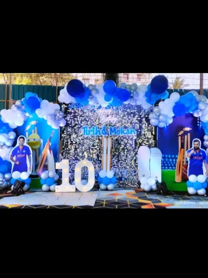 A perfect birthday party for a young cricket fan. This outdoor setup features a blue and white balloon arch, a sequin backdrop, and life-size cutouts of famous Indian cricketers.