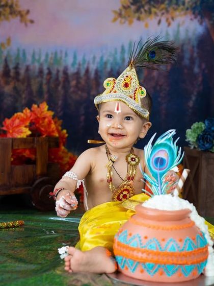 A happy little Krishna enjoying his birthday cake during a themed cake smash.