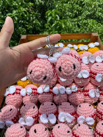 Holding up a pair of my pink bee keychains. This custom color was a fun project and shows the possibilities for your own unique order.