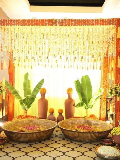 A traditional South Indian themed setup perfect for a Haldi ceremony. I used authentic elements like banana leaves, earthen matkas, and large woven baskets, all tied together with the auspicious colors of orange and yellow from marigold flowers.