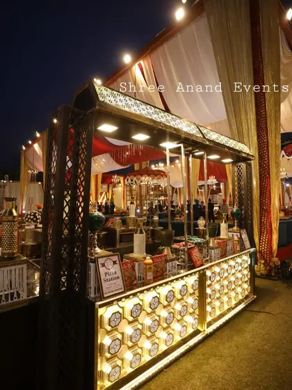 This is a beautifully illuminated live pizza station, designed to be a standout feature at an evening event. The warm lighting and stylish counter design make it an inviting spot for guests to grab a fresh slice.