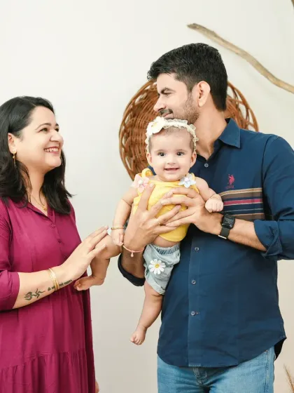 A happy family portrait celebrating their baby's six-month milestone. The love and pride in the parents' eyes are what make these photos so special.
