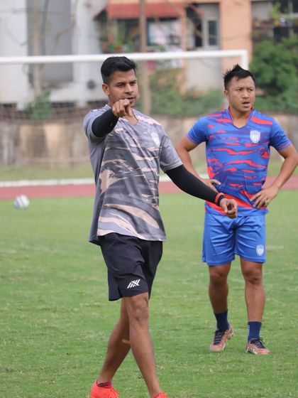 Directing players during a field session. Clear communication and instruction are essential for effective coaching.
