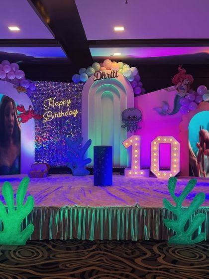 A different version of the mermaid theme for Dhriti's 10th birthday. This setup uses bold, colorful lighting and a sparkling "Happy Birthday" backdrop to create an exciting underwater world.