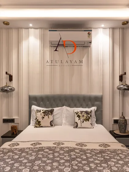 A simple yet stylish bedroom with a captivating feature wall of vertical grooves, a tufted light blue headboard, and modern pendant lights.