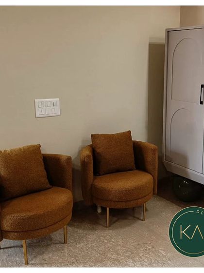 A pair of cozy, rounded armchairs in a warm, textured brown fabric with slim metal legs. These chairs are perfect for creating a comfortable reading nook or an intimate conversation area.