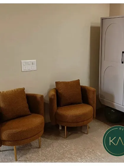 A pair of cozy, rounded armchairs in a warm, textured brown fabric with slim metal legs. These chairs are perfect for creating a comfortable reading nook or an intimate conversation area.