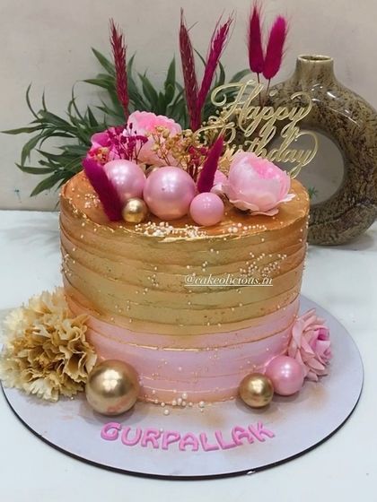 Our bestselling pink and golden design. This single-tier whipped cream cake is perfect for birthdays and anniversaries, featuring a beautiful ombre effect and decorated with fresh flowers, pink spheres, and dried grasses.