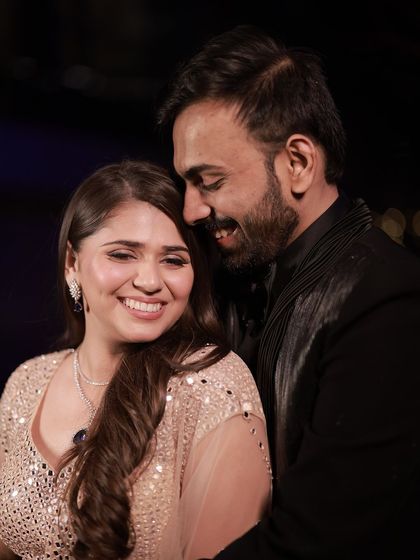 A happy couple at their Sangeet. The bride's simple, elegant waves are the perfect choice for a glamorous and fun-filled evening.