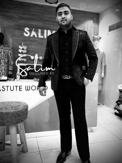 A black and white photo of a client in a fully sequined black tuxedo. The photo emphasizes the texture and shimmer of the all-over embellishment.