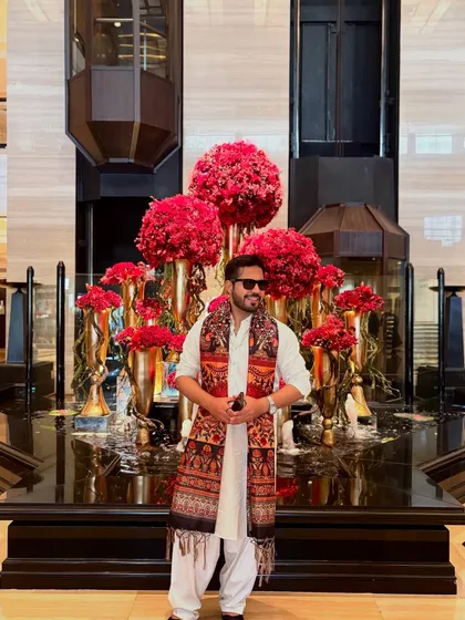 Posing in front of a grand floral decoration inside the hotel. The grandeur of the venue inspires my performance.