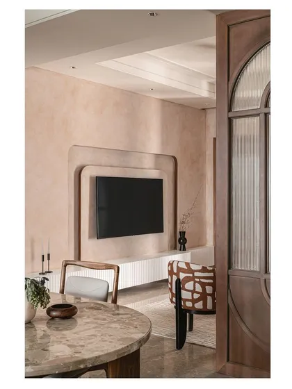 A wider shot showing the connection between the dining and living areas. The design uses partitions and consistent color palettes to define spaces while maintaining an open, connected feeling.