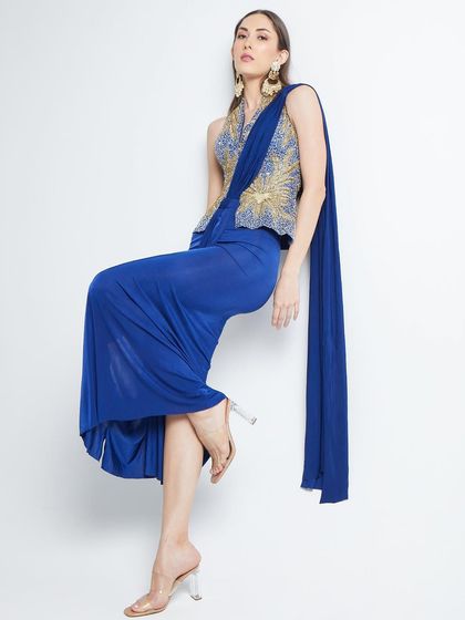 A creative, gravity-defying pose for The Luxury Pop, showcasing a stunning blue draped dress with an embellished bodice.