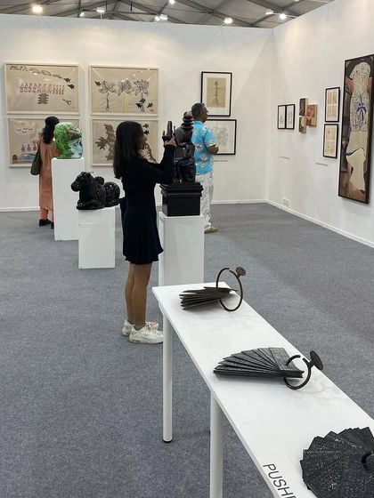 A visitor capturing a photo of a sculpture, a common sight at our engaging booths.