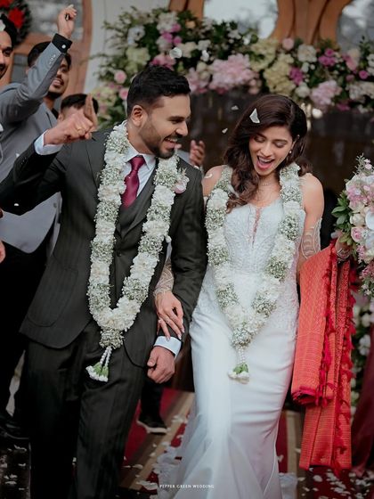 A joyful exit from the ceremony, showered with blessings and surrounded by loved ones. This candid moment captures the pure elation of being newly married.