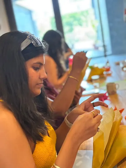 A participant is deeply focused on the intricate folds of an origami project. The quiet concentration during these workshops is often a welcome break from the hustle of daily life.