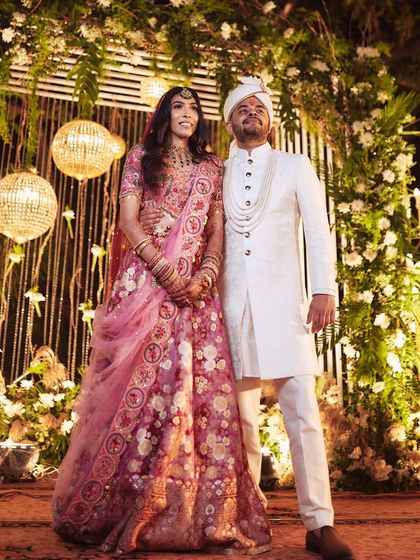A classic portrait of the couple against their wedding decor. Pallavi's soft pink look is both traditional and modern.