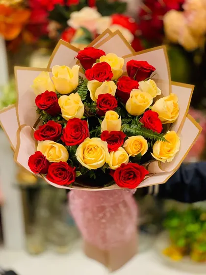 A top-down view of the red and yellow rose bouquet. This angle highlights the beautiful color combination and the freshness of the flowers.