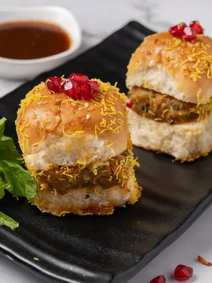 A taste of Mumbai's streets, elevated. Our mini Dabeli sliders are packed with a sweet and spicy potato filling, sev, and pomegranate.