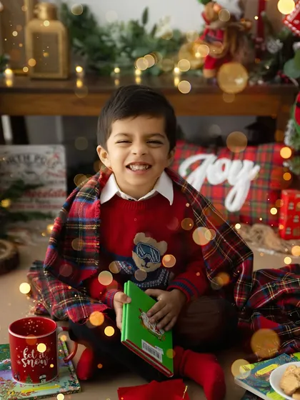 The magic of the holidays is best seen through a child's eyes. This cozy moment from a Christmas mini session, with warm lights and a festive blanket, captures the pure, unadulterated joy of the season.