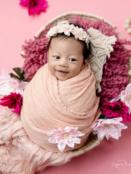 An adorable, awake, and smiling moment from our pink floral session.