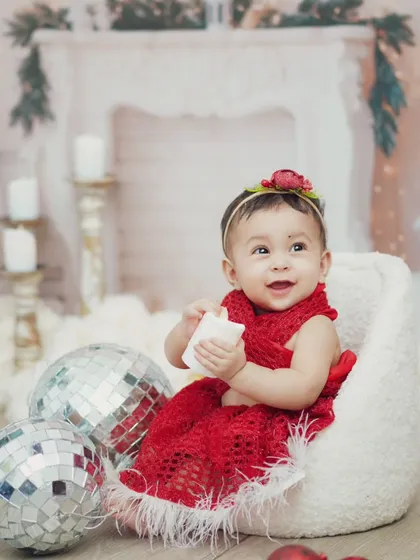 A festive red outfit and shiny disco balls make this Christmas shoot sparkle. I love capturing the joy and wonder of the holidays through a child's eyes.