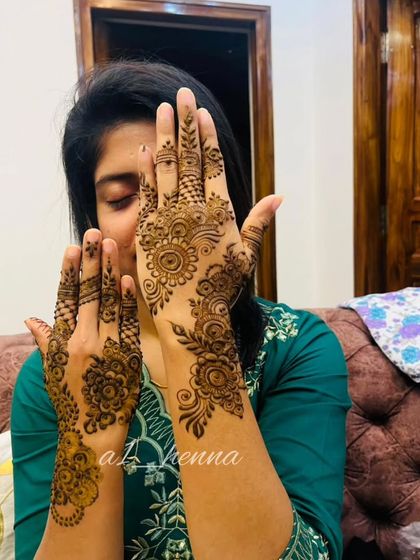 A client happily showing off her beautiful Arabic henna.